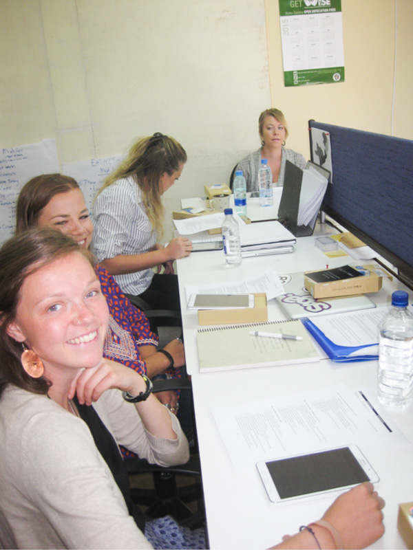 The students configure tablets in the Akros office for chiefs to access data related to progress on sanitation initiatives in their villages.