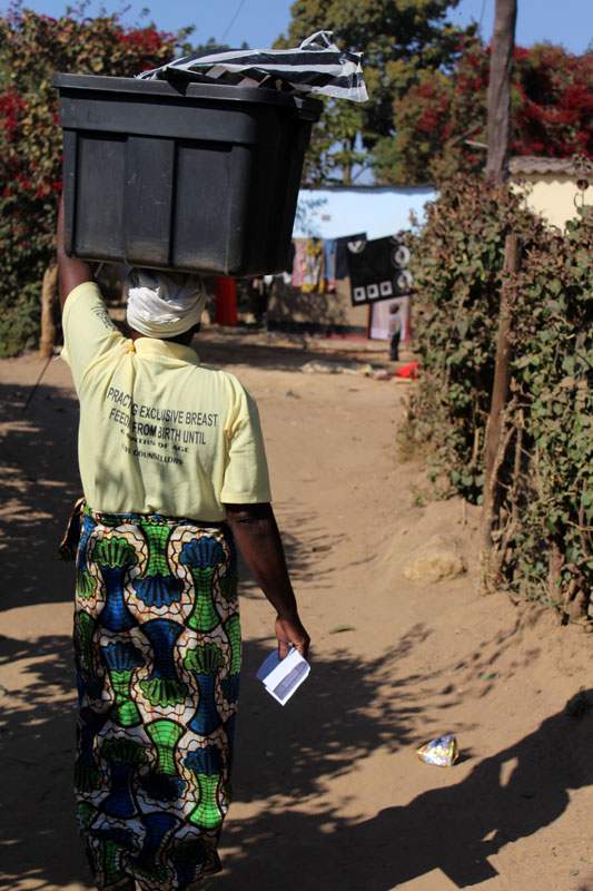 Nelie Tembo, a community health worker, walking to a house in Chainda compound for Reactive Case Detection.