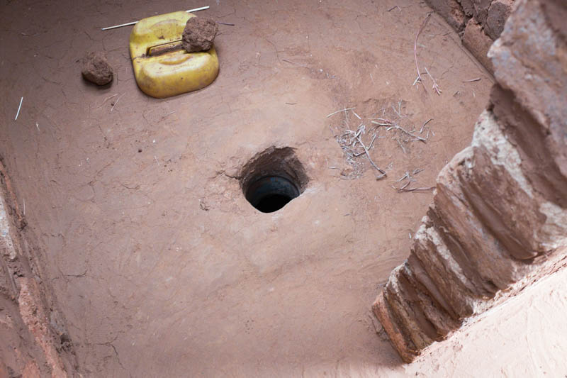 Latrines that meet proper sanitation guidelines should have a cleanable concrete floor and a lid to cover the hole.